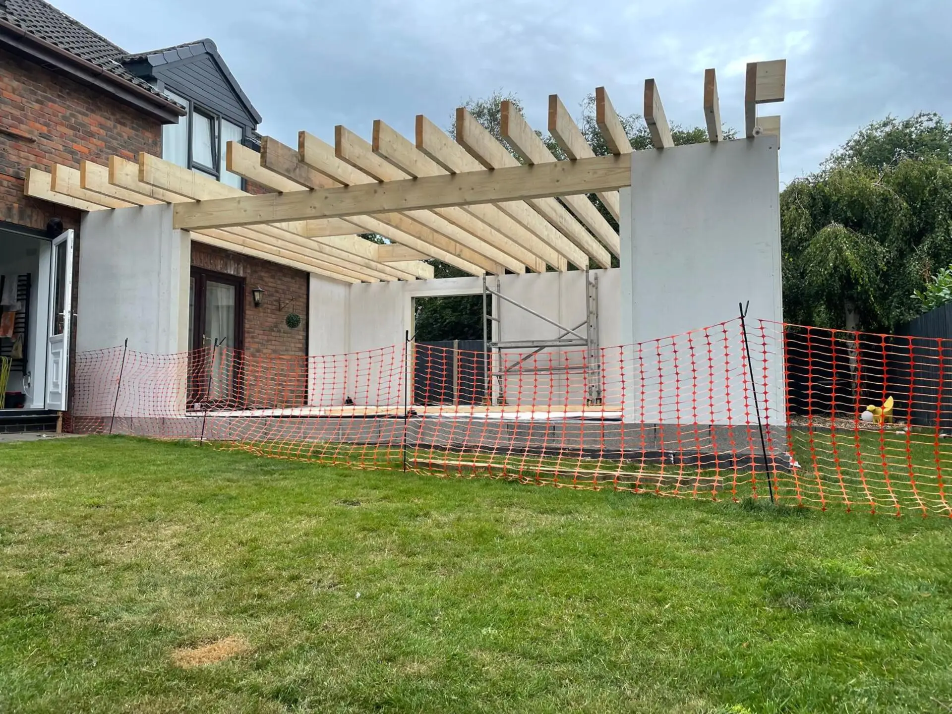 Modern rear extension with large glazed doors opening to garden - Mid Build